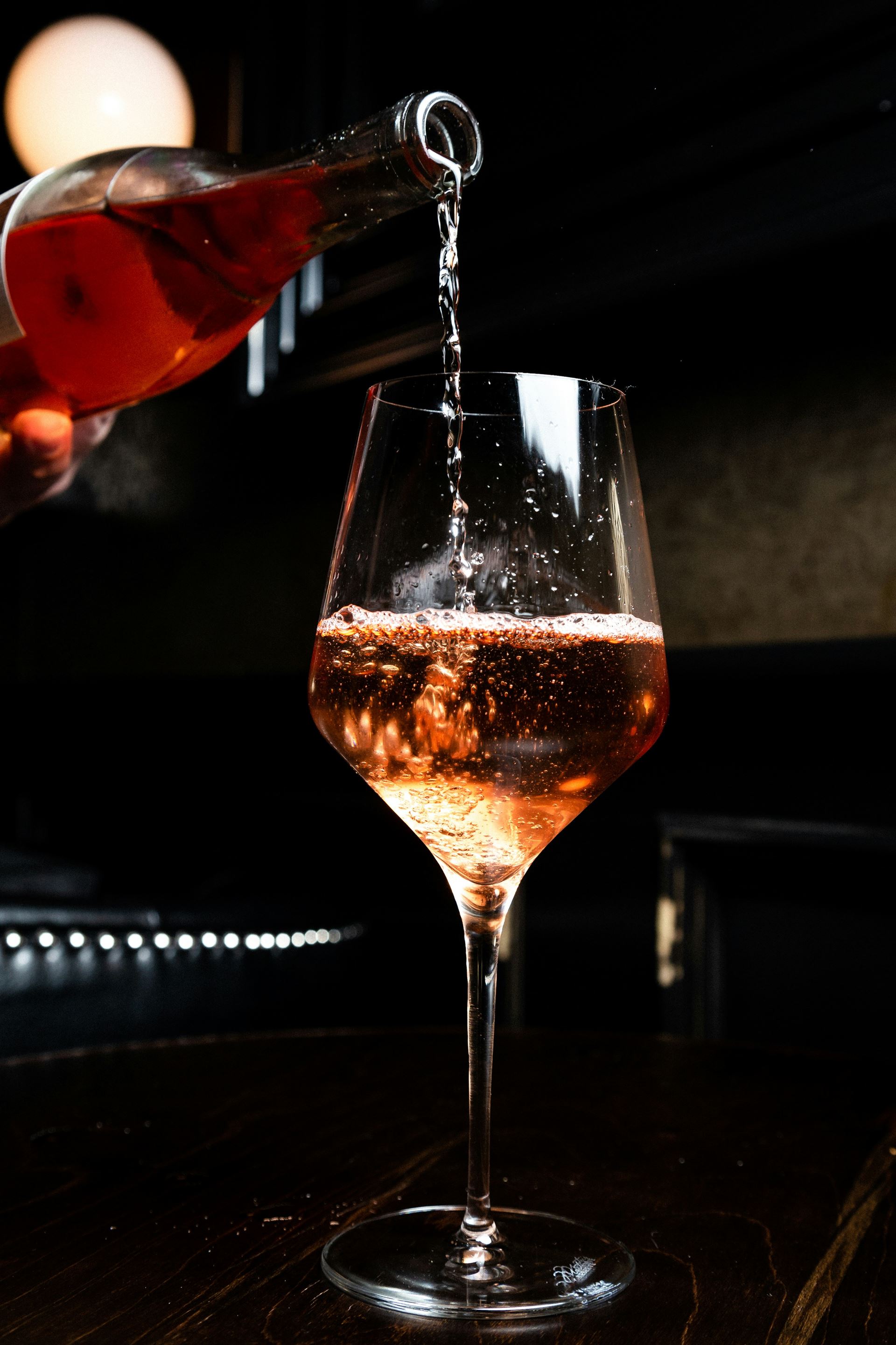 glass with alcohol being poured into it 